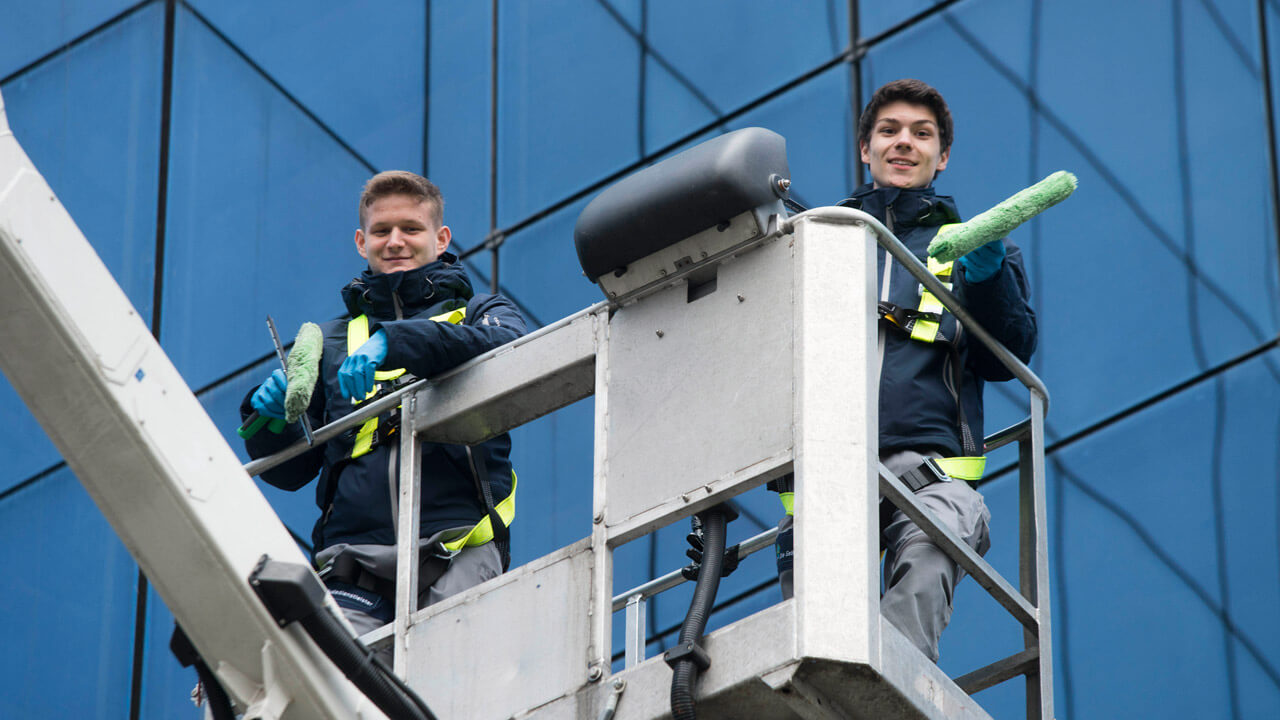 Mitarbeiter bei der Glasreinigung auf einer Hebebühne