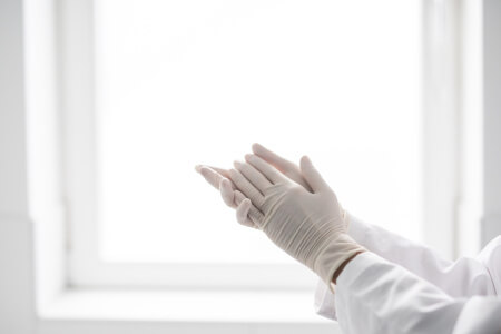 Reinigungskraft mit Handschuhen in stuttgarter Praxis